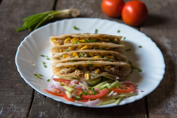 Tortilla with chicken and vegetable wraps on a plate with use of selective focus