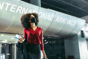 Wall Mural - Businesswoman with face mask on arrived at international airport