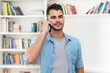 © Daniel Ernst - Hispanic hipster man in quarantine talking at mobile phone