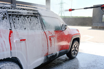 Wall Mural - Dirty car at the car wash in the foam. Car wash with soap