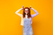 © Look! - Positive woman in sundress and sweatshirt posing with ice cream on orange background