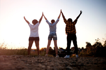 happy girls, of different nationalities, view from the back, at sunset in summer