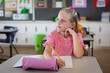 © WavebreakMediaMicro - Caucasian girl studying while sitting on her desk in the class at school