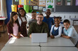 © Wavebreak Media - Portrait of caucasian male teacher and group of diverse students with laptop in the class at school