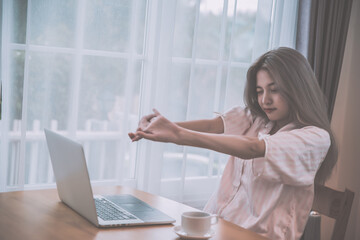 Lazy bored asian woman using laptop in the morning.