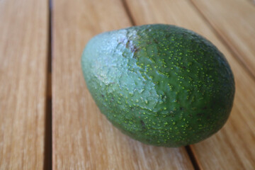 Sticker - Closeup of a large avocado on a wooden table