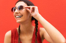 Stylish Woman In Sunglasses On Red Background