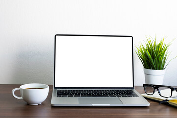 Front view of open laptop computer notebook with blank monitor white screen display on work table desk. Workspace office modern business online technology. Flat lay with blank copy space.