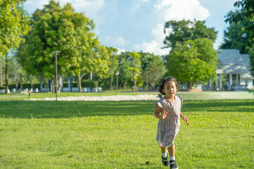 Wall Mural - Little girl running outdoor at grass field.