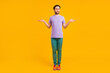 Photo of pretty unhappy young guy dressed purple t-shirt shrugging shoulders isolated yellow color background