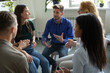 © fizkes - Work addict people talking on group therapy meeting, sitting in circle, discussing addiction, mental health problems. Counselor speaking, giving support and advice to team for successful recovery