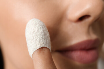 Wall Mural - Woman using silkworm cocoon in skin care routine, closeup