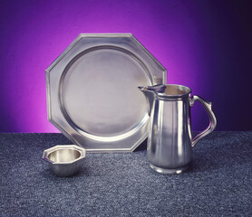 Wall Mural - Selective focus shot of a silver teapot, plate, and small container