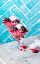 Blackberry Granita In A Cocktail Glass Against A Blue Background