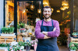 © Luis - Flower shop owner in an apron has his arms crossed in front of his flower store.