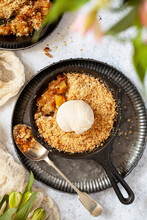 Pineapple Crumble In A Small Cast Iron Skillet With A Ball Of Vanilla Ice Cream On Top