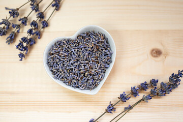 Wall Mural - Dried lavender flowers in a bowl on a wooden background.