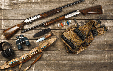 Wall Mural - Hunting equipment on old wooden background including rifle, knife, binoculars and cartridges