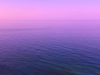 Wall Mural - pink sky sunrise over blue sea water. dawn over calm rippled ocean waves. pink sky sunrise over blue