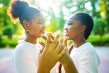 brazilian lesbian couple in white dress spending time together celebrating engagement in summer park outdoor