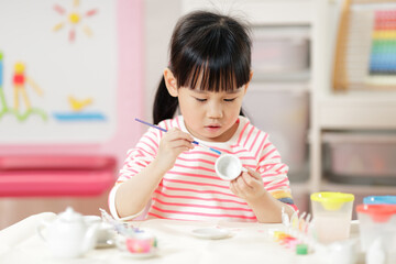 Wall Mural - young girl decorating hand made craft for homeschooling