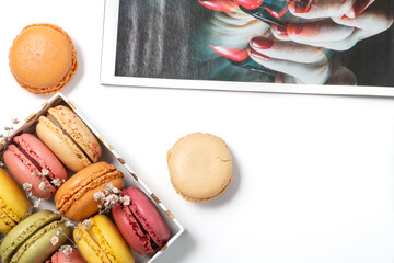 Wall Mural - french dessert macarons of different colours, fashion magazine and dry flowers on a white background 