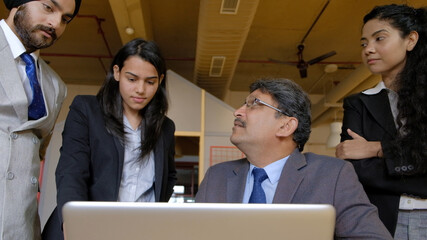 Poster - Group of Indian workers brainstorming during a business meeting in office