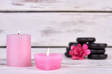 Wall Mural - Pink wax candles with stones and flower for spa.