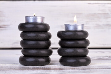 Wall Mural - Stacks of black stones with candles for spa therapy.