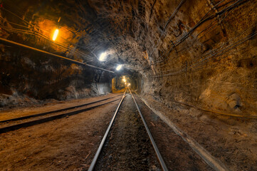 Wall Mural - Tunnel of the mining of an underground mine. Lots of pipelines on the ceiling and rail track for trolleys