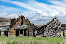 A Crumbling, Derelict, Abandoned Old Farmhouse Falling Apart In The Field