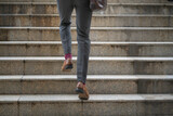 Fototapeta Na drzwi - close up legs of businessman walking stepping up stair in the city. successful,grow up concept