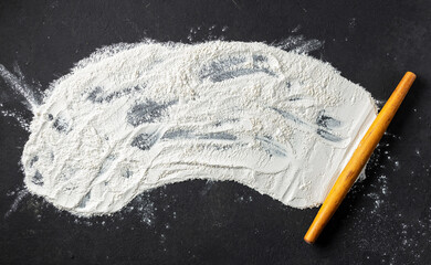 Poster - Abstract baking background with flour and rolling pin on black table top view