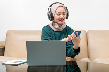 Wall Mural - Asian Muslim businesswoman using a laptop working from home