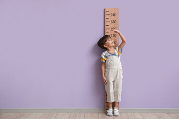 Wall Mural - Little boy measuring height near color wall