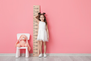 Sticker - Little girl measuring height near color wall