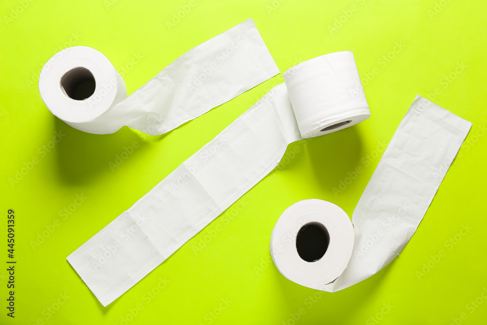 Rolls of toilet paper on color background