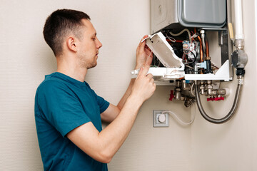 Wall Mural - a man repairing a boiler in a medical mask