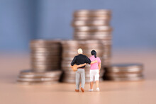 Couple Dolls Walking Towards A Pile Of Coins