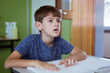 © WavebreakMediaMicro - Blind caucasian schoolboy sitting at desk in classroom reading braille book with fingers