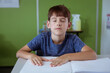 © WavebreakMediaMicro - Blind caucasian schoolboy sitting in classroom with eyes closed reading braille book with fingers