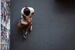 © WavebreakMediaMicro - Overhead view of african american schoolgirl sitting on floor reading book in school library