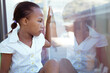 © WavebreakMediaMicro - African american schoolgirl sitting in school classroom looking out of window