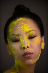 Wall Mural - Portrait of asian woman with yellow powder paint