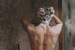 © ViDi Studio - Back rear view young brunet half naked torso topless brunette man 20s taking hot shower wash hair with shampoo indoors in bathroom at home. People healthcare daily morning routine lifestyle concept