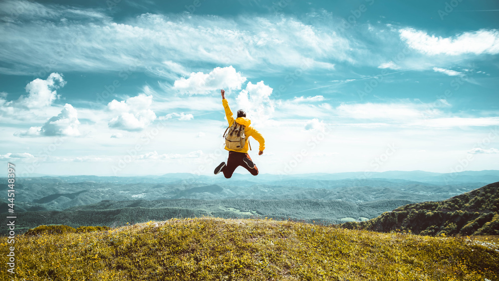 Hiker with backpack raising hands jumping on the top of a mountain - Successful man with arms up enjoying victory - Sport and success concept	
 - obrazy, fototapety, plakaty 