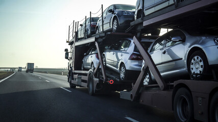 Sticker - Car transporter trailer loaded with many cars on a highway, motion blur effect.