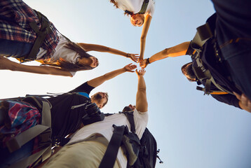 Wall Mural - star shaped handshake of young smiling tourists hikers hiking together on nature during vacations in