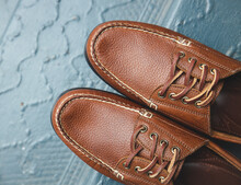 Leather moc boat shoes for men on a set of colorful stairs for a fashion image of footwear.