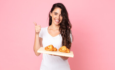 Wall Mural - pretty young woman holding a croissant tray